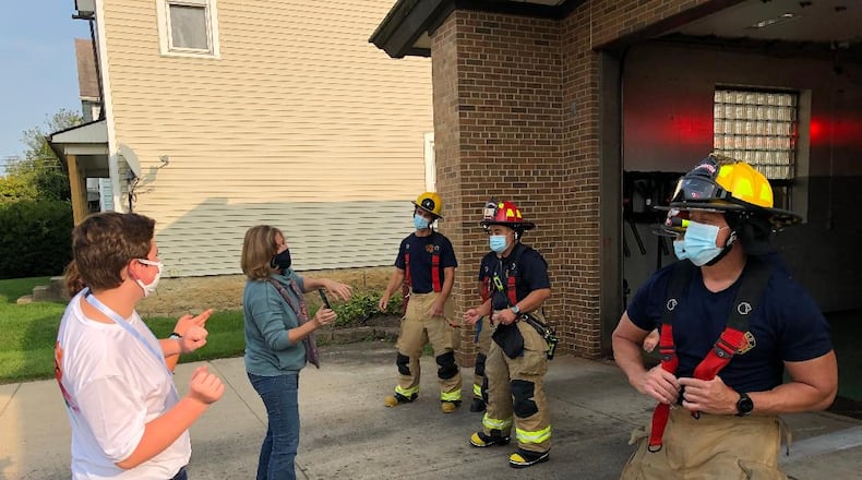 Noah Chesshir, left, and Beth Dixon rehearse with firefighters from Springfield's Station 8 prior to shooting a TikTok video for First Responder Appreciation Week in Springfield. Photo by Brett Turner