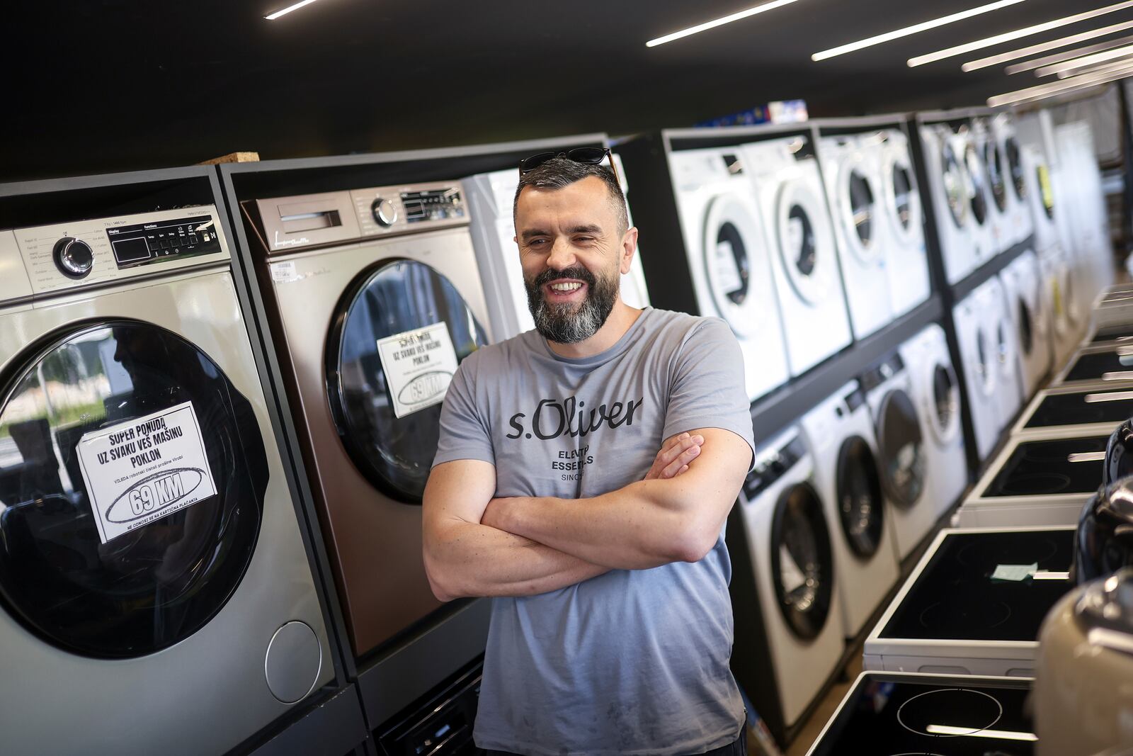 Mirnes Fatic, one of the owners of "Only fools and horses ltd." home appliance store, smiles during an interview for the Associated Press in Hadzici, suburb of Sarajevo, Bosnia, Wednesday, June 4, 2025. (AP Photo/Armin Durgut)