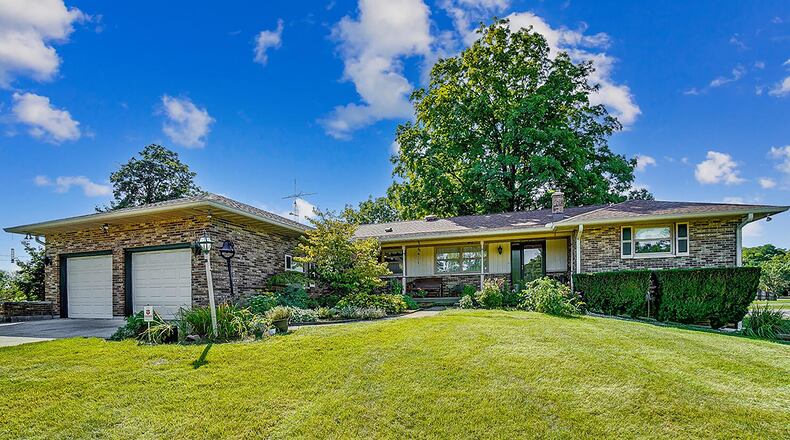 The brick ranch home includes about 2,330 sq. ft. of living space with a walk-out, partially finished basement. The home features a covered front porch and has an attached, 2-car garage and detached, 2-car garage/outbuilding. CONTRIBUTED PHOTO