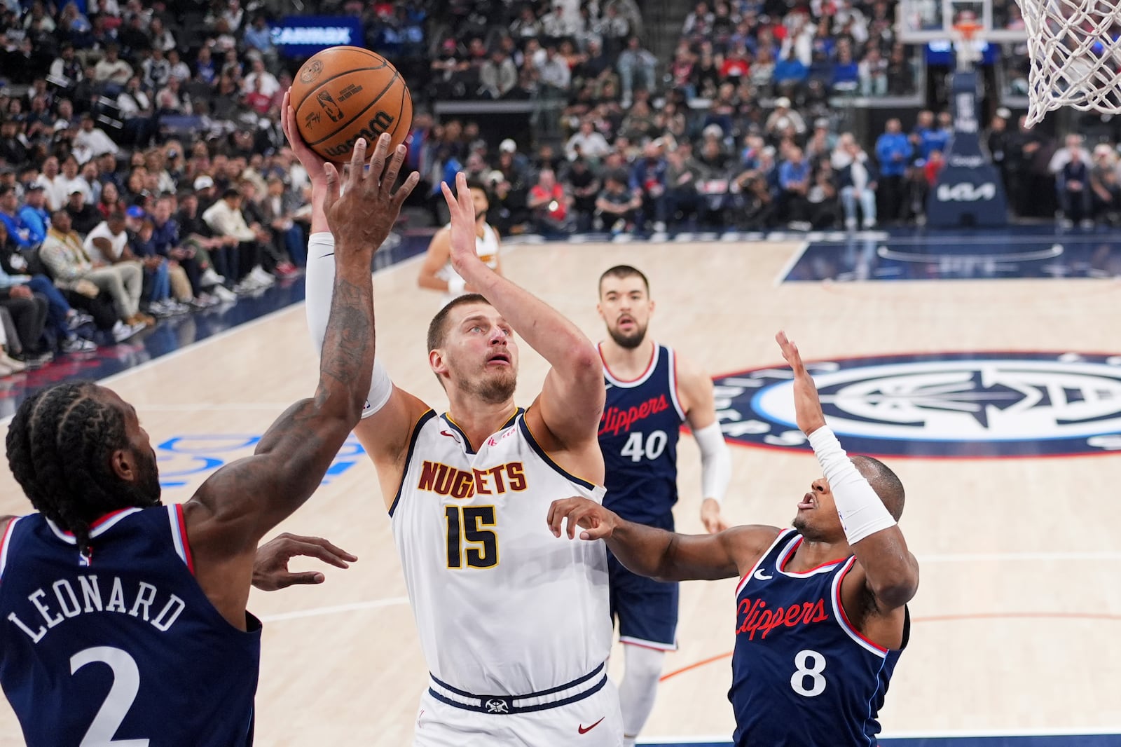 Denver Nuggets center Nikola Jokic, second from left, shoots as Los Angeles Clippers forward Kawhi Leonard, left, and guard Kris Dunn defend during the first half in Game 6 of an NBA basketball first-round playoff series Thursday, May 1, 2025, in Inglewood, Calif. (AP Photo/Mark J. Terrill)
