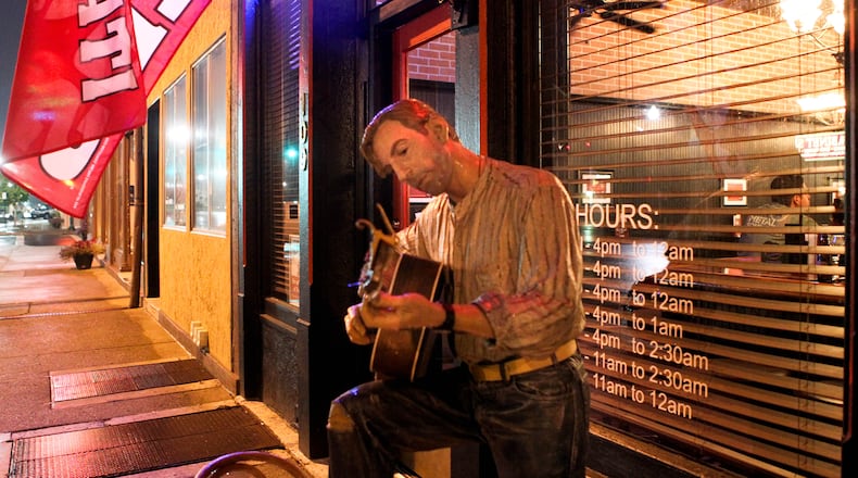 A Seward life-like sculpture outside of Mojo's Bar and Grill in downtown Troy. JIM WITMER / STAFF