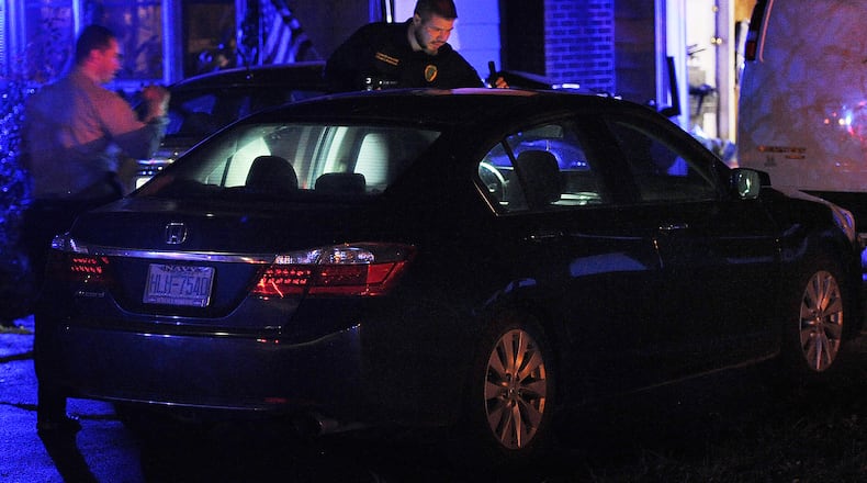 Members of the Springfield Police Division look over a car at a home on Selma Pike Sunday night Nov. 6, 2022 involved in homicide on Willis Ave. in Springfield. MARSHALL GORBY\STAFF