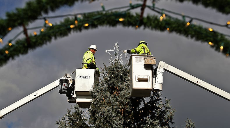 Two City of Springfield workers decorating the Springfield Holiday Tree in downtown Springfield in 2020. BILL LACKEY/STAFF