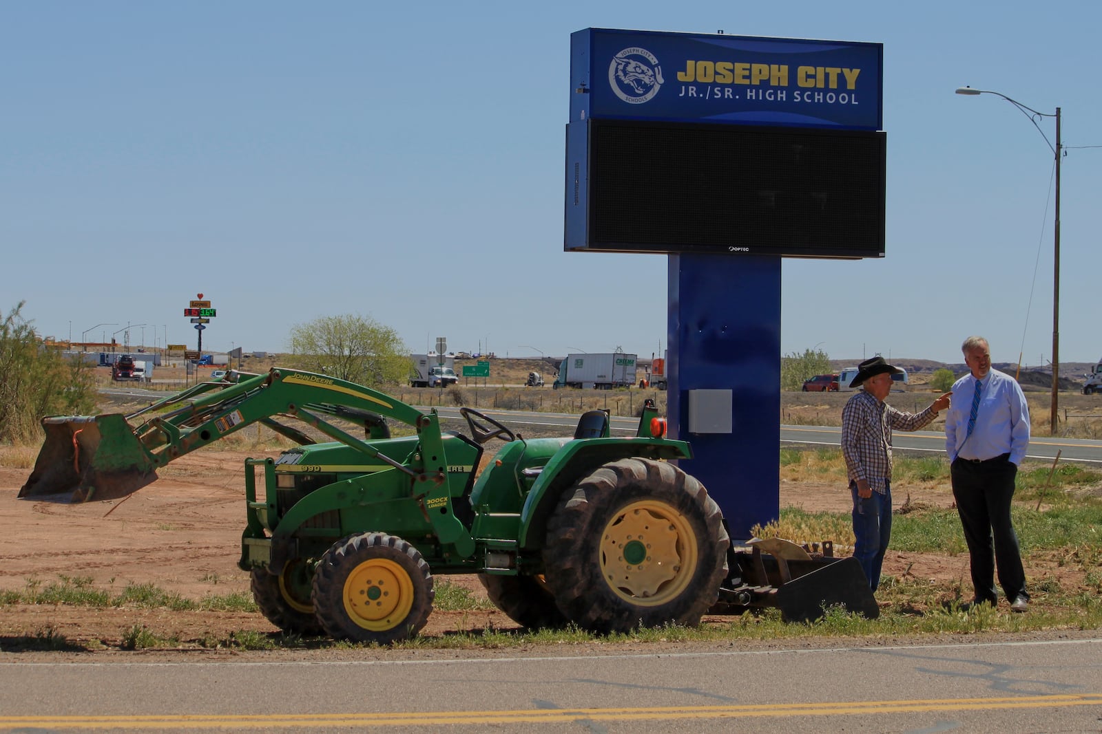 Rancher Brantley Baird, left, and Joseph City School Superintendent Bryan Fields discuss a historical marker near the high school sign in Joseph City, Ariz., Wednesday, April 23, 2025. (AP Photo/Susan Montoya Bryan)