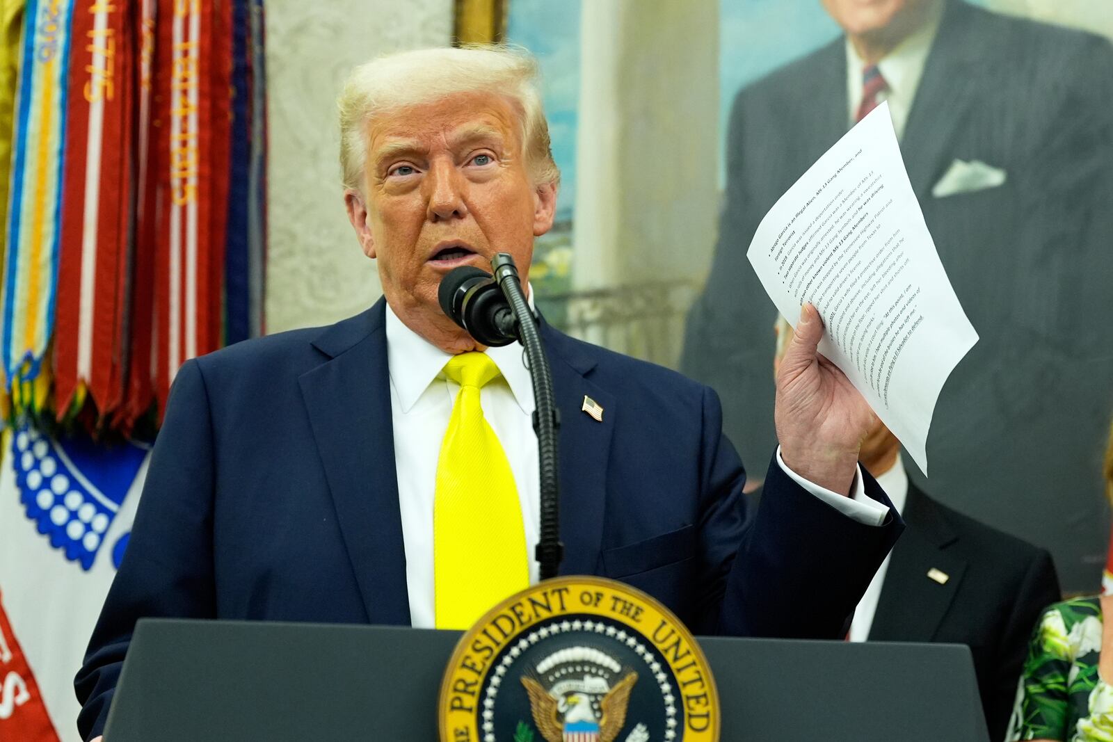 FILE - President Donald Trump holds a document with notes about Kilmar Abrego Garcia as he speaks with reporters in the Oval Office of the White House, April 18, 2025, in Washington.(AP Photo/Alex Brandon, File)