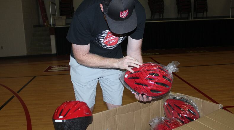 Ryan Ray with The Salvation Army Springfield Corps. looks over some of the helmets that were donated by Clark County-Springfield Transportation Coordinating Committee. JEFF GUERINI/STAFF