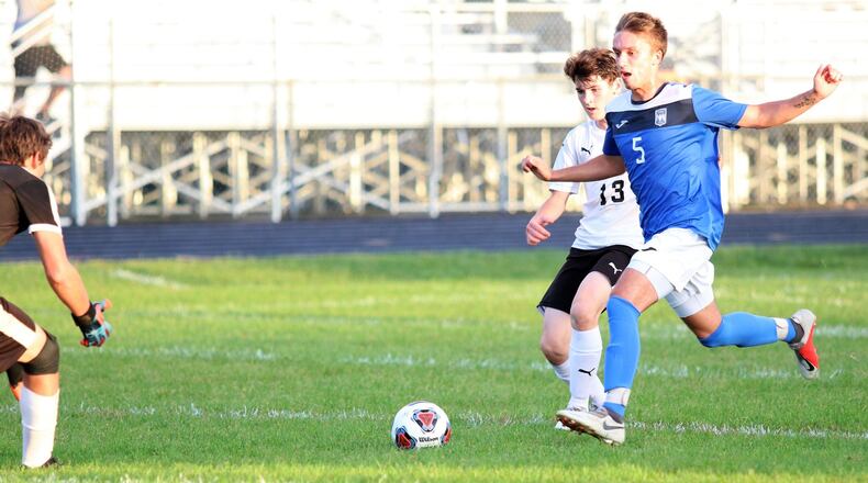 Northwestern High School’s Evan Noffke and Shawnee’s Matt Holland chase the ball as it rolls towards the Braves’ goal during the Warriors 5-1 win over Shawnee on Monday, Sept. 17. Michael Cooper/CONTRIBUTED