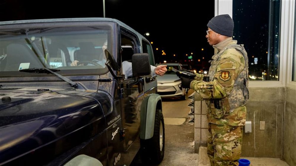 An airmen with the 88th Security Forces Squadron checks an identification card at Gate 15A at Wright-Patterson Air Force Base on Feb. 25, 2025. (Air Force photo by Jack Gardner)