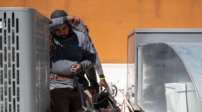 Brian Hermosillo wipes sweat from his brow while installing a new air conditioning unit during record-breaking heat Thursday, March 19, 2026, in Tempe, Ariz. (AP Photo/Caitlin O'Hara)