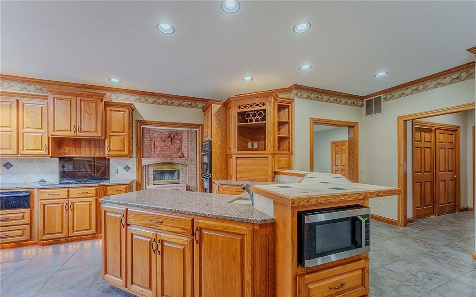The kitchen has tile flooring, wood cabinets with granite countertops, a breakfast bar and recessed lighting. Appliances include a cook top, double wall ovens, a microwave and dishwasher. CONTRIBUTED