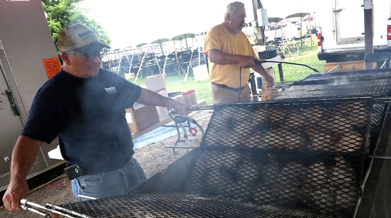 Joe Fitzgerald, left, and Dale Monnin cook a batch of the world famous pork chops Friday at the Clark County Fair in 2018. Pork chops like these will be on sale in South Vienna to pick up Saturday, Sept. 10, 2022. BILL LACKEY/STAFF