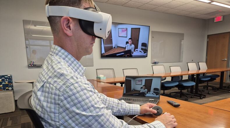 Nate Kincaid, associate professor of nursing at Cedarville University, interacts with an AI-generated patient using a VR headset. MICHAEL KURTZ / STAFF