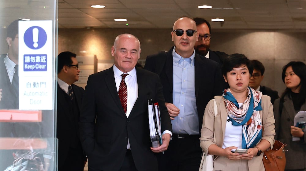 Selina Cheng, right, chair of the Hong Kong Journalists Association (HKJA) and a former reporter for The Wall Street Journal (WSJ), leaves Eastern Magistrates' Court during a session break, together with her legal team, barrister Nicklaus Pannu-Yuon, left, senior counsel Nigel Kat, second left and solicitor Adam Paul Clermont, center back, for her case against the paper's parent company, Dow Jones Publishing Co (Asia) Inc., in Hong Kong on Thursday, Dec. 18, 2025. (AP Photo/May James)