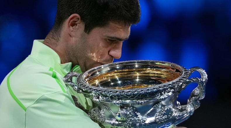 Carlos Alcaraz of Spain holds the Norman Brookes Challenge Cup after defeating Novak Djokovic of Serbia in the men's singles final at the Australian Open tennis championship in Melbourne, Australia, Sunday, Feb. 1, 2026. (AP Photo/Aaron Favila)