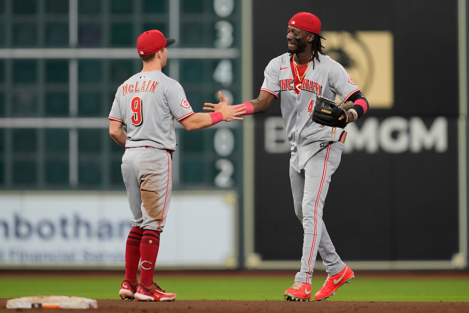 Cincinnati Reds second baseman Matt McLain (9) and shortstop Elly De La Cruz (44) celebrate after winning a baseball game against the Houston Astros in Houston, Saturday, May 10, 2025. (AP Photo/Ashley Landis)