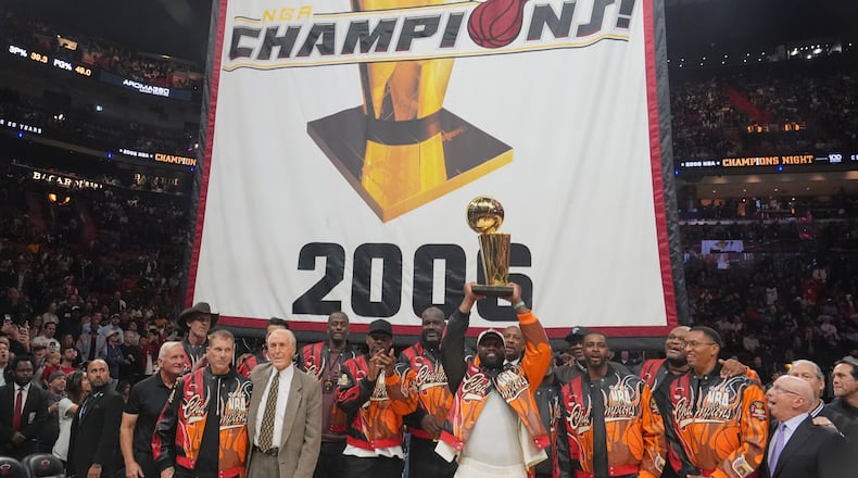 The Miami Heat 2006 NBA championship team pose with the trophy during a half time celebration Tuesday, Feb. 3, 2026, in Miami. (AP Photo/Marta Lavandier)