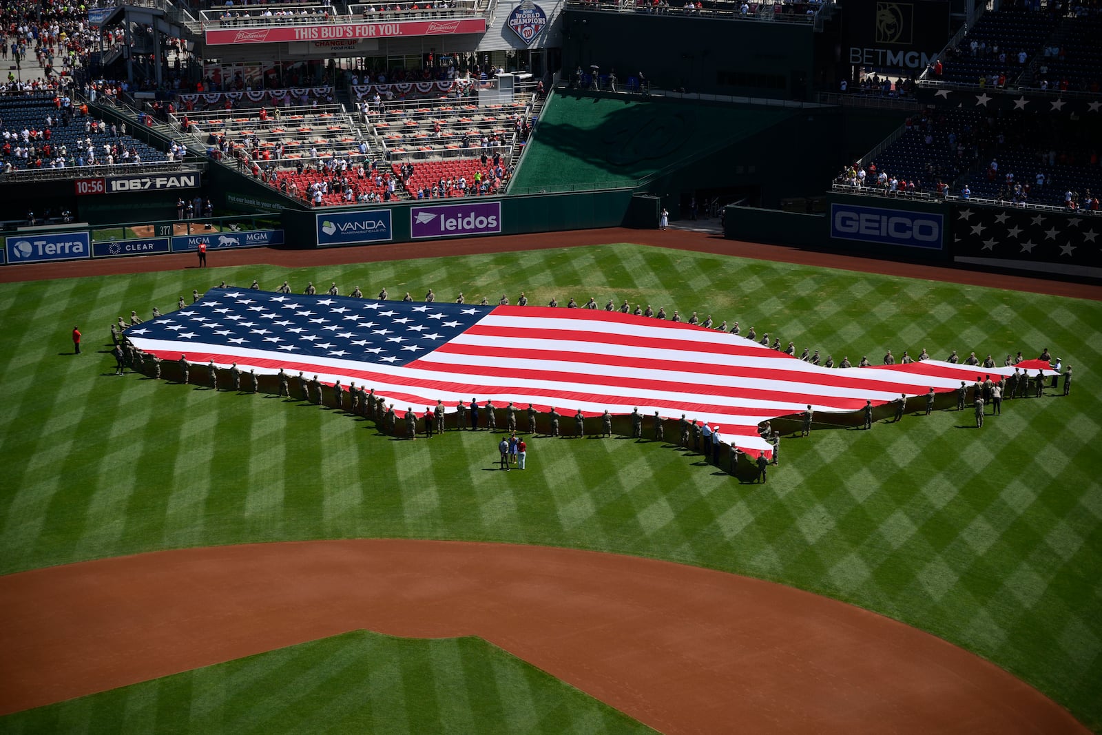 An American flag in the shape of the continental United States is displayed on the field before a baseball game between the Washington Nationals and the Boston Red Sox, Friday, July 4, 2025, in Washington. (AP Photo/Nick Wass)