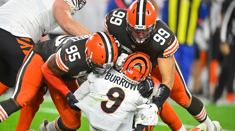 Cincinnati Bengals quarterback Joe Burrow (9) is sacked by Cleveland Browns defensive end Myles Garrett (95) and Taven Bryan (99) during the second half of an NFL football game in Cleveland, Monday, Oct. 31, 2022. (AP Photo/David Richard)