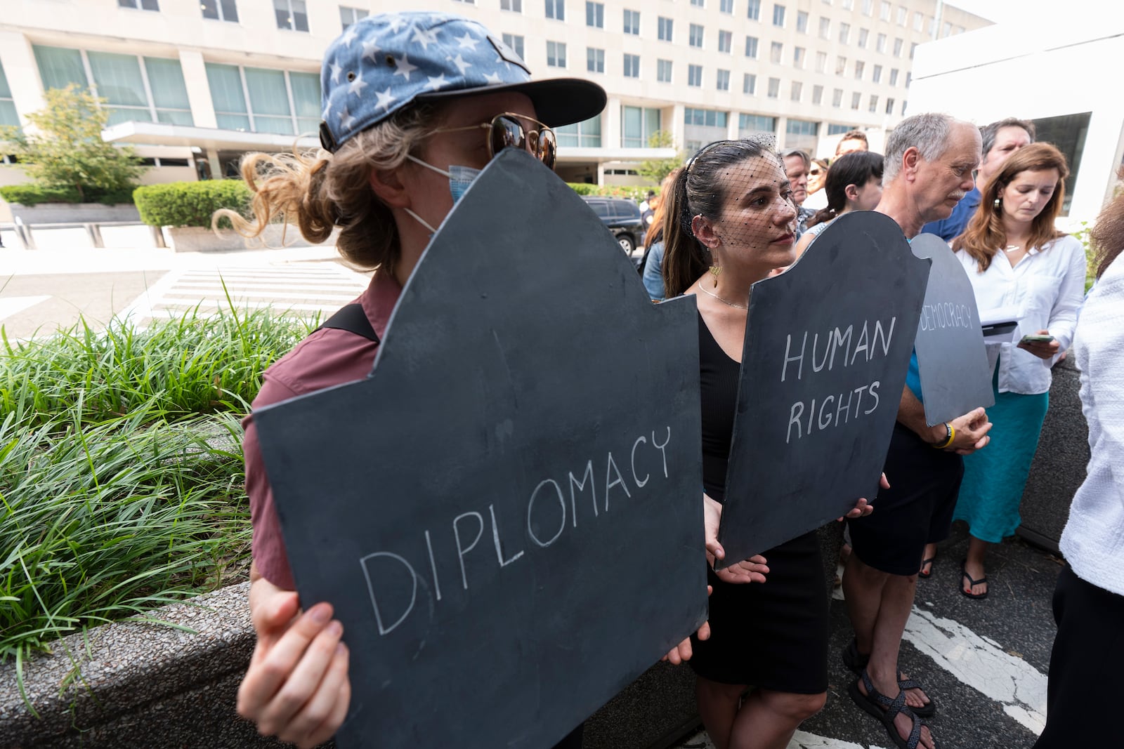Retired State Department employees and supporters rally outside the Harry S. Truman Building, the headquarters of the State Department, in Washington, Friday, July 11, 2025. (AP Photo/Manuel Balce Ceneta)
