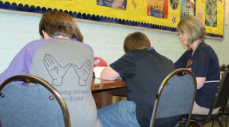 Possum School teacher, Jamie Boysel helps students with their Social Studies class in a hallway because of overcrowding. JEFF GUERINI/STAFF
