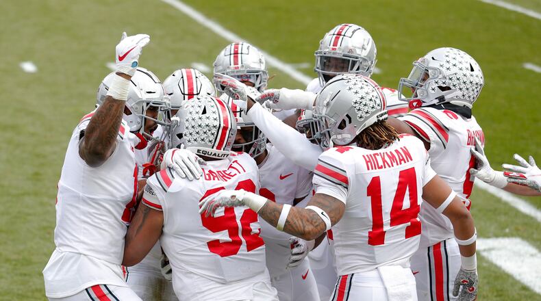 Ohio State players celebrate with Haskell Garrett (92) after his touchdown on an interception during the first half of an NCAA college football game against Michigan State, Saturday, Dec. 5, 2020, in East Lansing, Mich. (AP Photo/Al Goldis)
