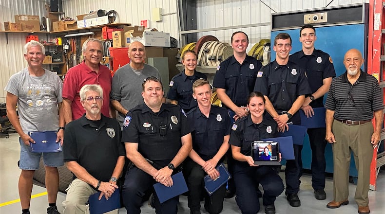 Group photo of firefighters and paramedics with Abe Awabdy, an elderly man, on the right.