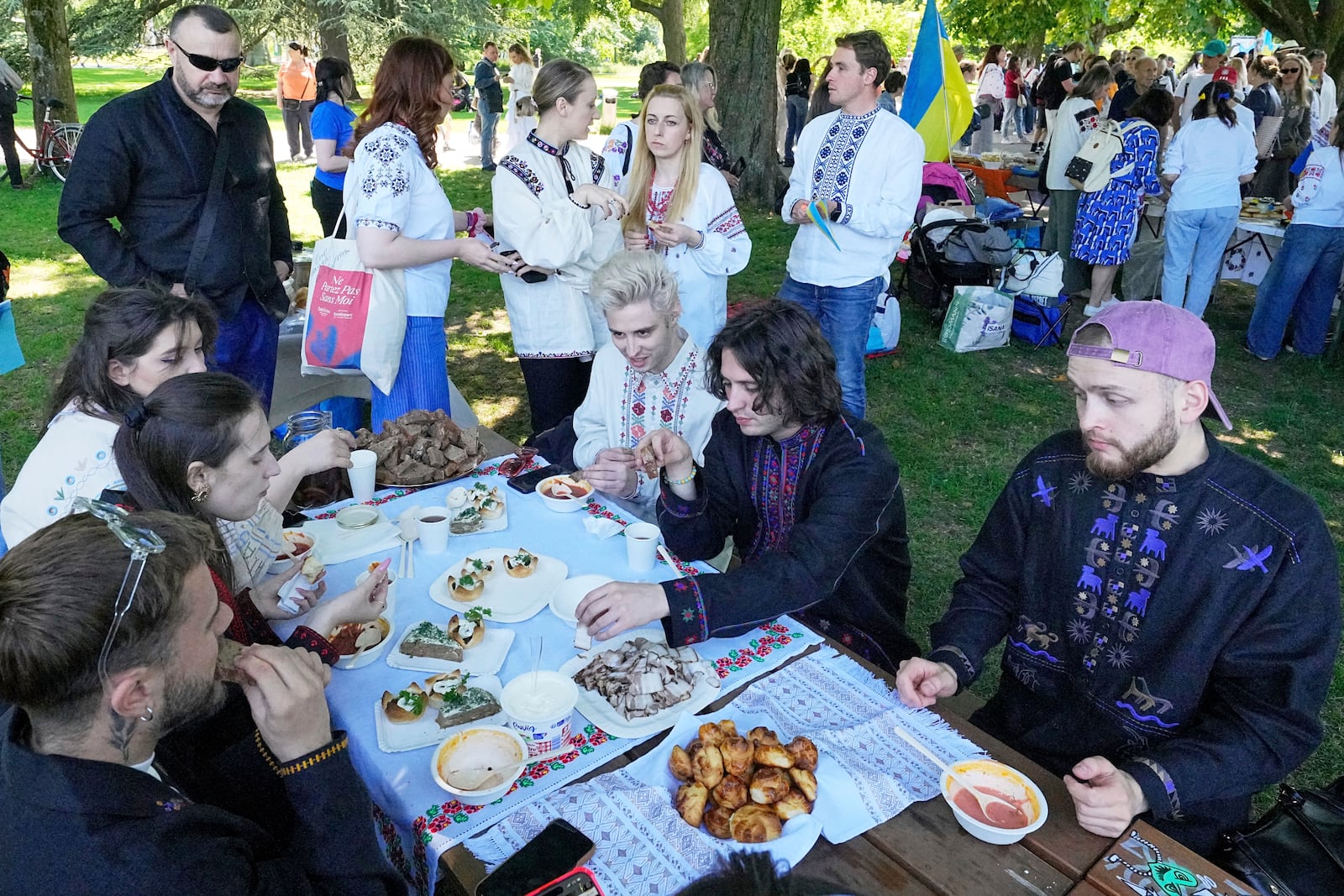 Eurovision competitor band Ziferblat from Ukraine eats traditional food during a family meeting of Ukrainian people in a park in Basel as part of the 69th Eurovision Song Contest week, in Basel, Switzerland, Thursday, May 15, 2025. (AP Photo/Martin Meissner)