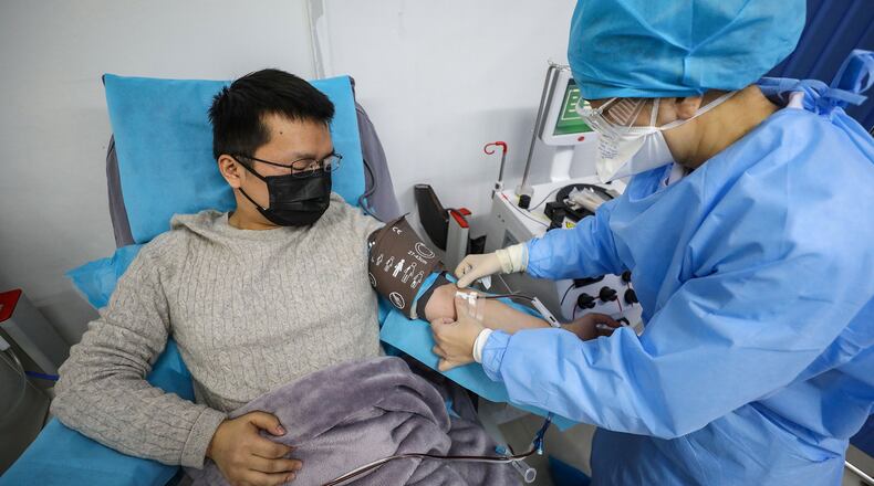 This photo taken on February 18, 2020 shows a doctor, left, who has recovered from the COVID-19 coronavirus infection donating plasma in Wuhan, China. (AFP/Getty Images/TNS)