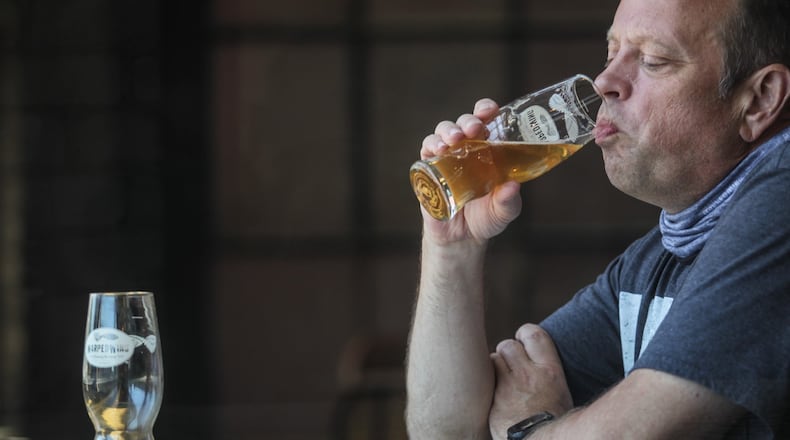 Marvin Most from Bellbrook enjoys a beer at Warped Wing Brewery on Wyandot Street Friday afternoon. House Bill 674, which now goes to the Senate for consideration, calls for making several changes to Ohio’s liquor laws as a means of helping bars and restaurants hit hard by the coronavirus shutdown. JIM NOELKER/STAFF