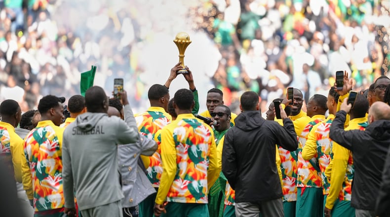 Senegal players celebrate with the Africa Cup of Nations trophy ahead of the international friendly soccer match between Senegal and Peru in Saint-Denis, outside of Paris, Saturday, March 28, 2026. (AP Photo/Aurelien Morissard)