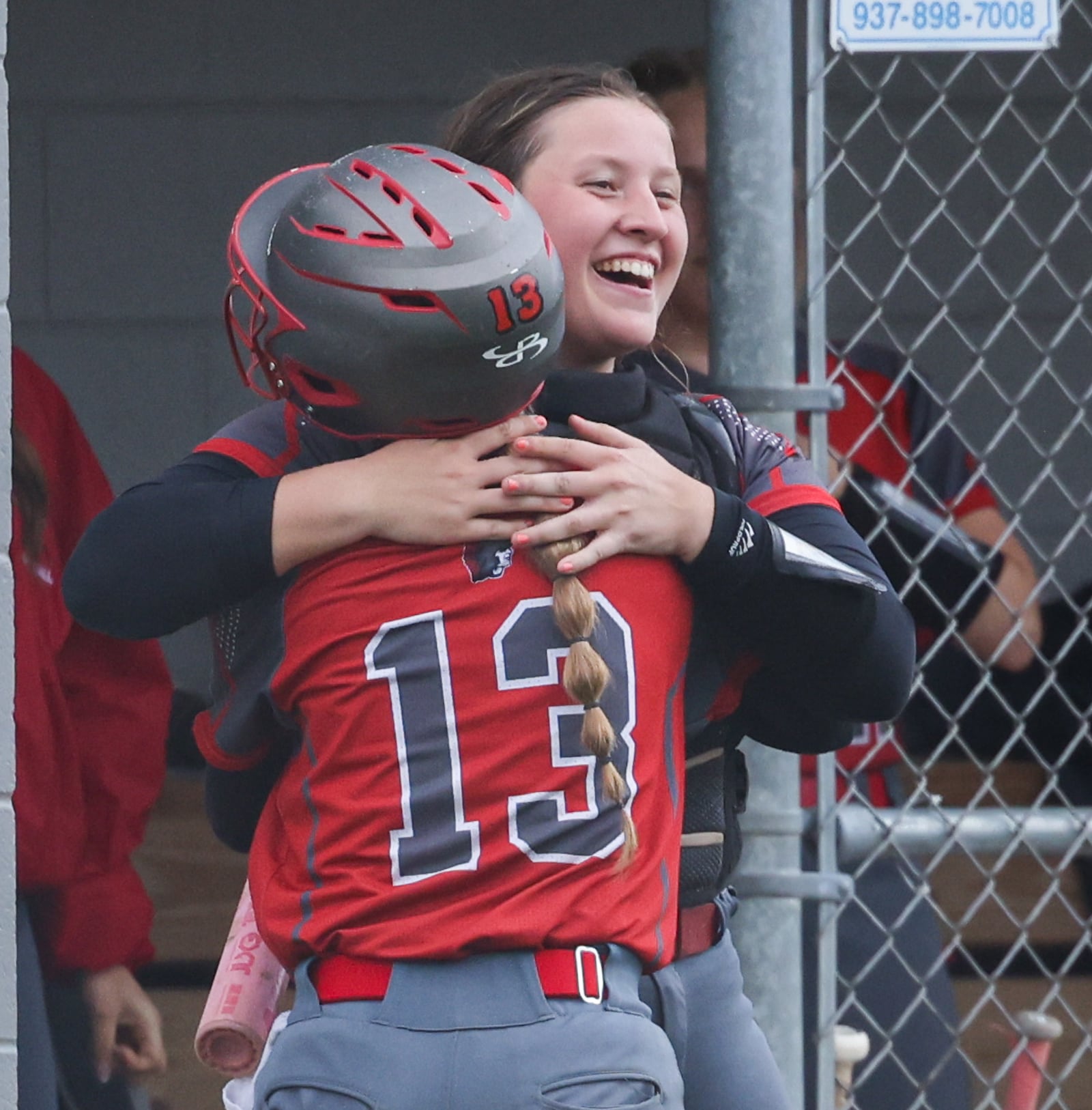 Southeastern junior catcher Kaylee Wells celebrates with junior Addi Vanover after Vanover scored a run during a Division VII regional semifinal against Waynesfield-Goshen on Wednesday at Northmont High School. BRYANT BILLING / STAFF