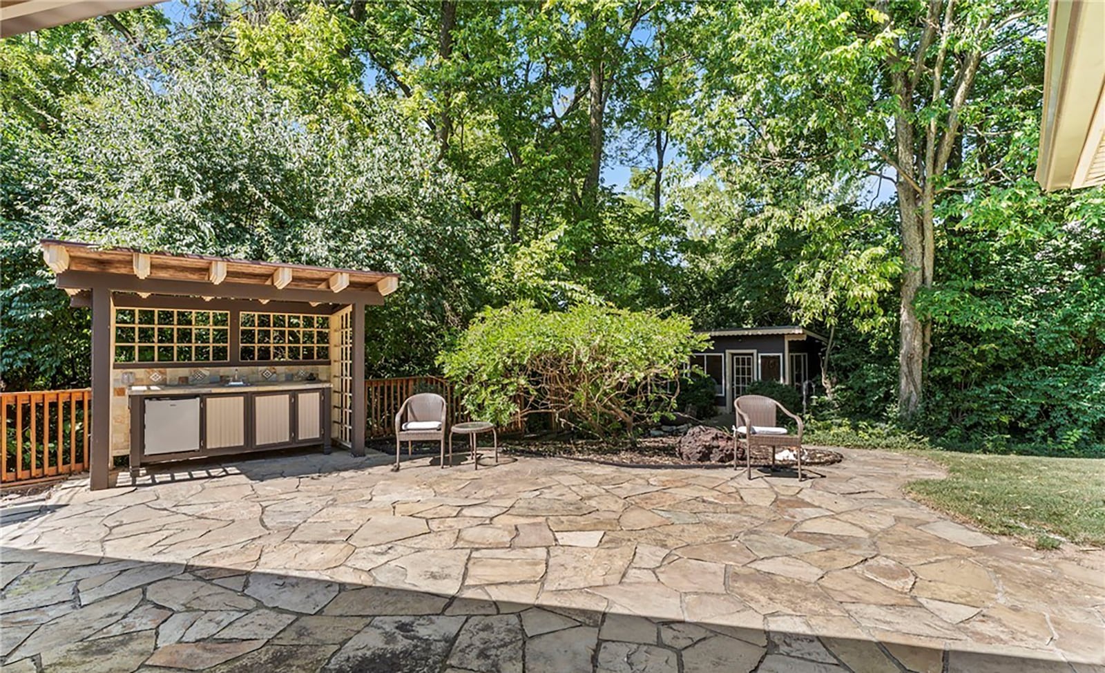 The back yard has an oversized flagstone patio, outdoor kitchen with pergola and a guest house with a woodburning stove. CONTRIBUTED