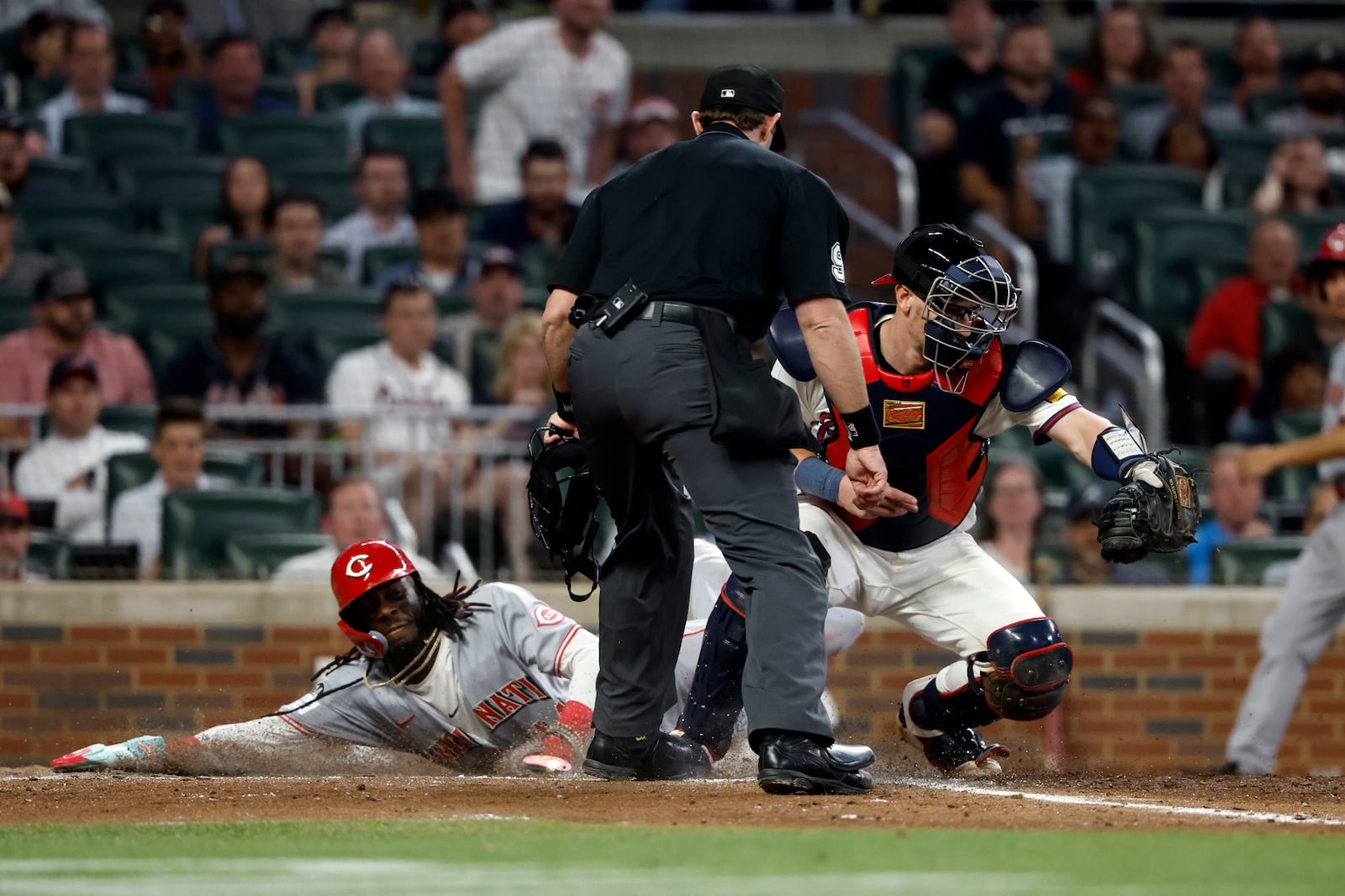 Cincinnati Reds' Elly De La Cruz (44) beats the throw to Atlanta Braves catcher Sean Murphy (12) as he slides safely into home plate during the eighth inning of a baseball game, Tuesday, May 6, 2025, in Atlanta. (AP Photo/Butch Dill)