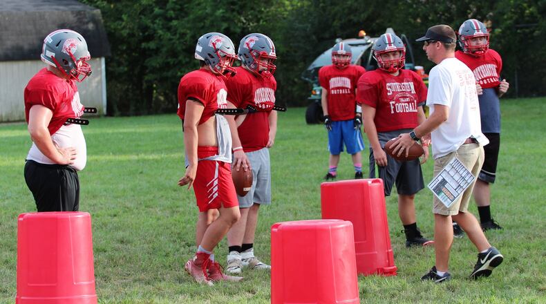 Southeastern High School offensive coordinator A.J. Woods instructs the Trojans’ line during practice on Thursday, Aug. 3, 2018. Woods was named head coach of the Trojans this week. MICHAEL COOPER / CONTRIBUTED