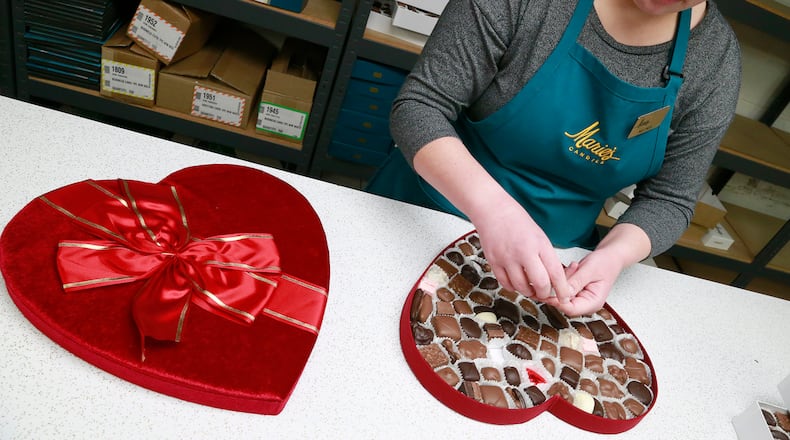 Melinda Bailey, an employee of Marie’s Candies, fills a three pound, heart shaped box of chocolates in 2017. Valentine’s Day is the second busiest time of the year for the West Liberty company as they make all their candy by hand. Their first busiest holiday is Christmas. BILL LACKEY/STAFF