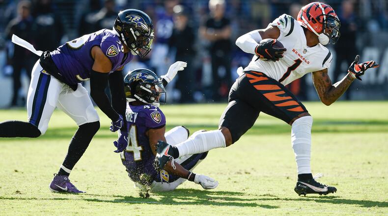 Baltimore Ravens safety Chuck Clark (36) and cornerback Marlon Humphrey (44) miss a tackle of Cincinnati Bengals wide receiver Ja'Marr Chase (1) before he took off for a long touchdown on a reception during the second half of an NFL football game, Sunday, Oct. 24, 2021, in Baltimore. (AP Photo/Gail Burton)