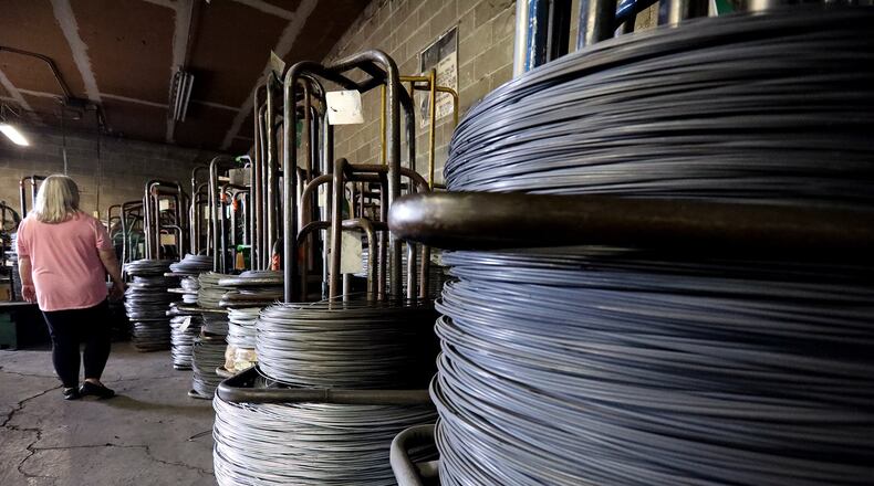 Sue Exelby, an employee of Stalder Spring Works, Inc., walks past coils of steel used to make the springs in their Springfield factory Monday, July 16, 2018. Bill Lackey/Staff