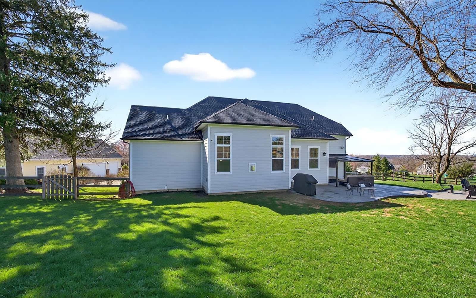 The backyard is surrounded by a wood fence and has a partially covered patio. There is also an additional patio with a stone firepit. CONTRIBUTED
