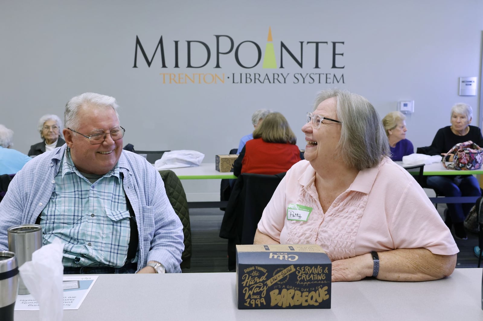 Paul Hilton, left, and Patty Sullivan laugh as they gather for lunch and fellowship at the MidPointe Library in Trenton Wednesday, Nov. 22, 2023. Then Lunch and Leisure for Seniors event happens on Wednesdays at the Trenton branch and those 60+ can enjoy free lunch, activities and time to connect with other Seniors. Registration is required. NICK GRAHAM/STAFF