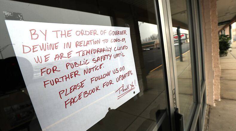 A sign on the door of a local nail salon explains why their closed Thursday. BILL LACKEY/STAFF