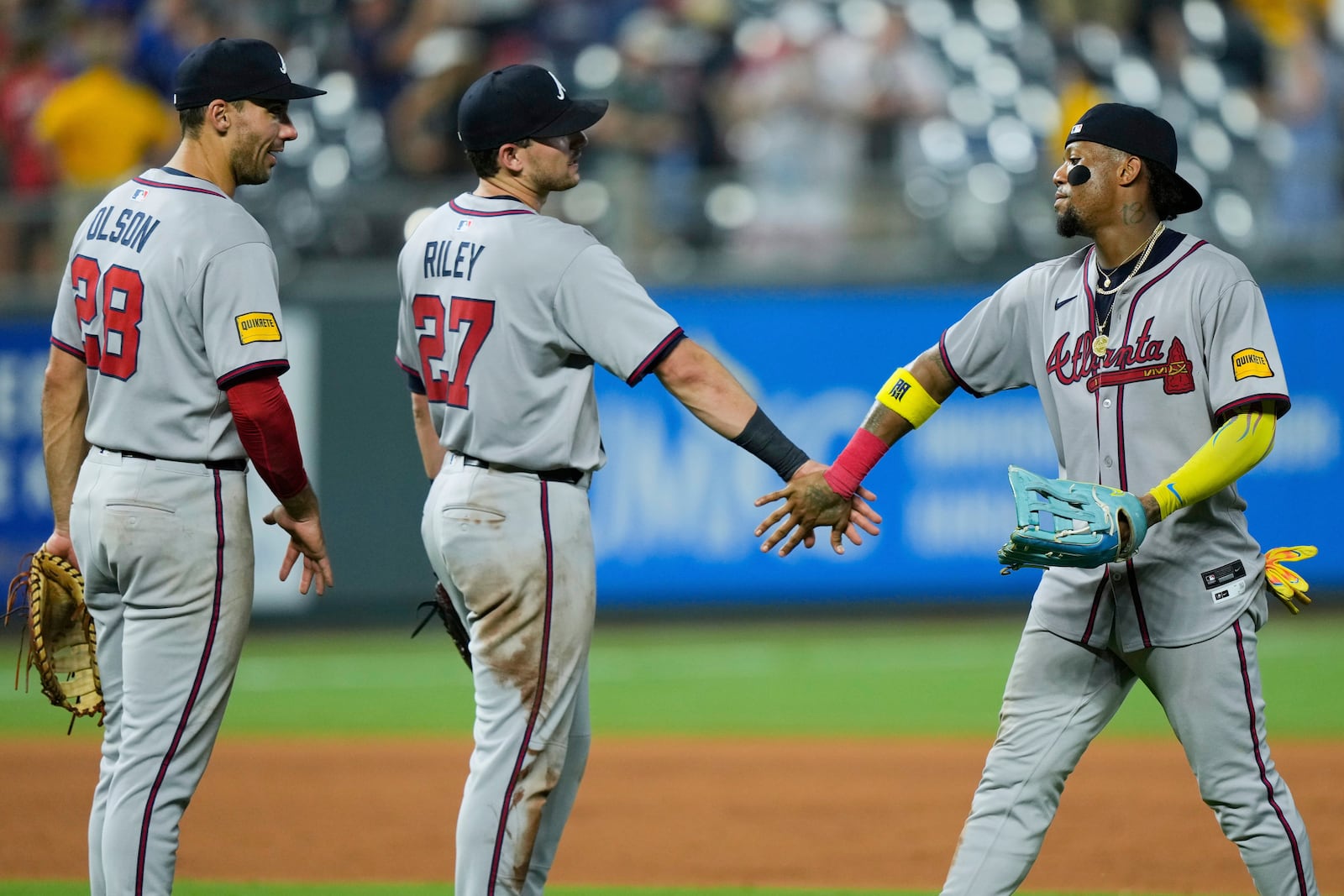 Atlanta Braves' Matt Olson (28), Austin Riley (27) and Ronald Acuna Jr. celebrate after their baseball game against the Kansas City Royals, Monday, July 28, 2025, in Kansas City, Mo. (AP Photo/Charlie Riedel)