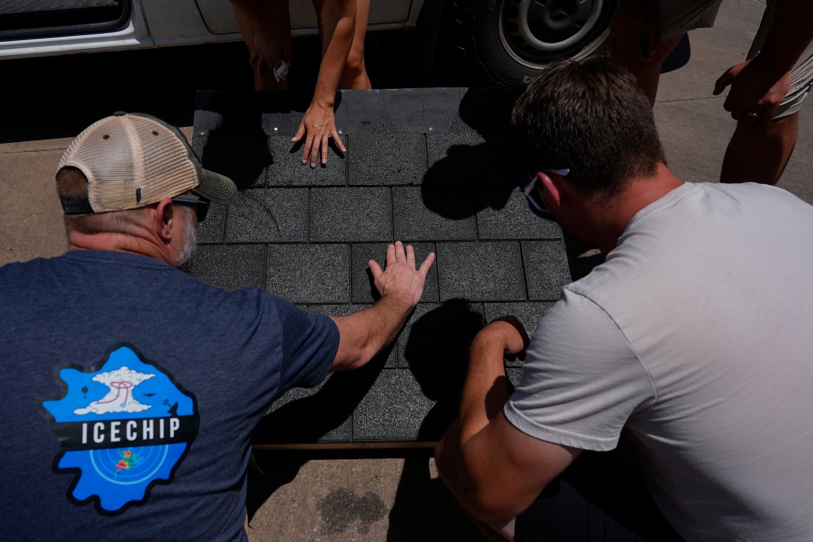 Members of Project ICECHIP inspect shingles for hail damage during an operation Friday, June 6, 2025, in Morton, Texas. (AP Photo/Carolyn Kaster)