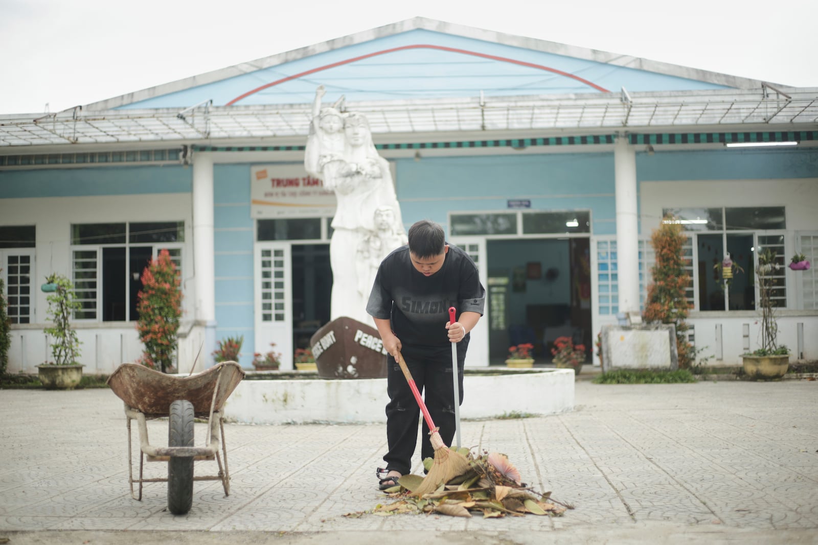 A student sweeps the area in front of a school for victims of Agent Orange in Da Nang, Vietnam, March 7, 2025. (AP Photo/Aniruddha Ghosal)