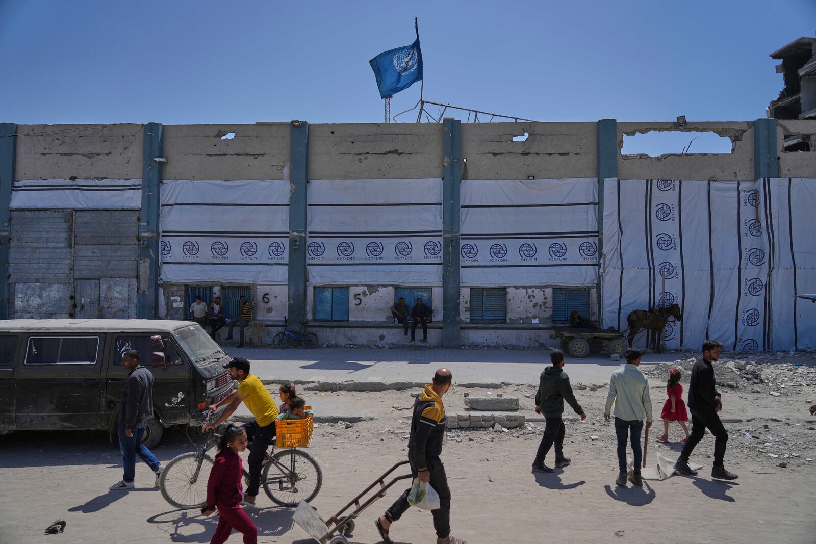 FILE - Palestinians walk next to the closed humanitarian aid distribution center of UNRWA, the U.N. agency helping Palestinian refugees in Jabaliya, Gaza Strip on Tuesday, April 29, 2025. (AP Photo/Jehad Alshrafi, File)