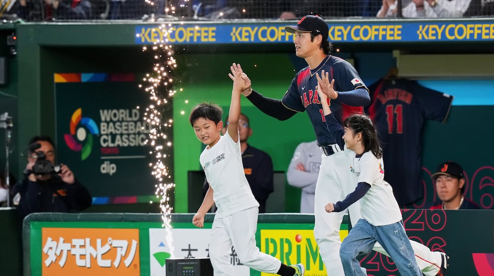 Japan's Shohei Ohtani enters the arena with young escorts before the start of a World Baseball Classic Pool C game between Japan and Taiwan Friday, March 6, 2026 in Tokyo. (AP Photo/Eugene Hoshiko)