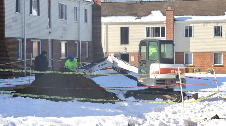 A work crew repairs the broken water line that left the residents of Sunset Apartments without water over the weekend. BILL LACKEY/STAFF