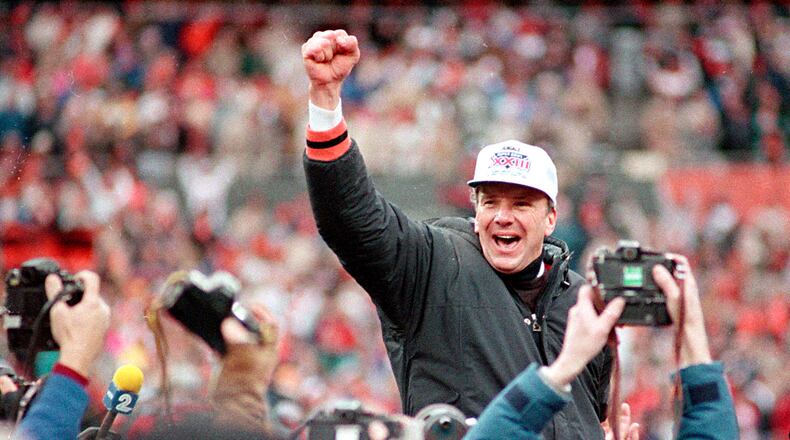 ** CORRECTS DATE TO JAN. 8, 1989, NOT JAN. 9, 1989 ** FILE ** Cincinnati Bengals coach Sam Wyche stabs the air as he is carried from the field on the shoulders of his players after their 21-10 victory over the Buffalo Bills for the AFC Championship game in Cincinnati , Ohio, in this Jan. 8, 1989 photo. A healthier, happy Sam Wyche is still in the game _ even if his to-do list at Pickens High includes things he never would have thought about in the NFL. Sweep out the locker rooms? You bet. Simplify his vast playbook for the high school game? Easily done. Watch his starting quarterback take a few days away from camp to play baseball? Not a problem. (AP Photo/Rob Burns)