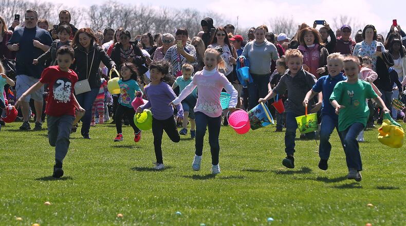 Hundreds of children and their parents scramble across the driving range at Young's Jersey Dairy as they participate in the 37th annual Easter Egg Hunt at Young's Dairy Sunday. The Dairy started with a few dozen eggs and a couple children has turned into a monumental event where they color 10,000 hard boiled eggs each year for hundreds of children. BILL LACKEY/STAFF