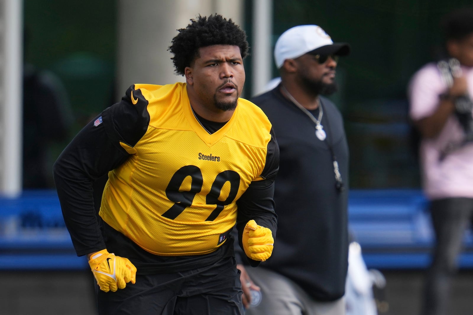 Pittsburgh Steelers head coach Mike Tomlin, right, watches as first round draft pick Derrick Harmon (99) warms up during the during the NFL football team's rookie camp in Pittsburgh, Friday, May 9, 2025. (AP Photo/Gene J. Puskar)
