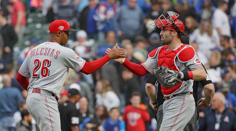 CHICAGO, ILLINOIS - MAY 24: Raisel Iglesias #26 of the Cincinnati Reds
is congratulated by Tucker Barnhart #16 after pitching for a save in the 9th inning against the Chicago Cubs at Wrigley Field on May 24, 2019 in Chicago, Illinois. The Reds defeated the Cubs 6-5. (Photo by Jonathan Daniel/Getty Images)